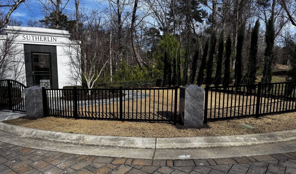 Black ornamental fence along curved brick pathway in Georgia