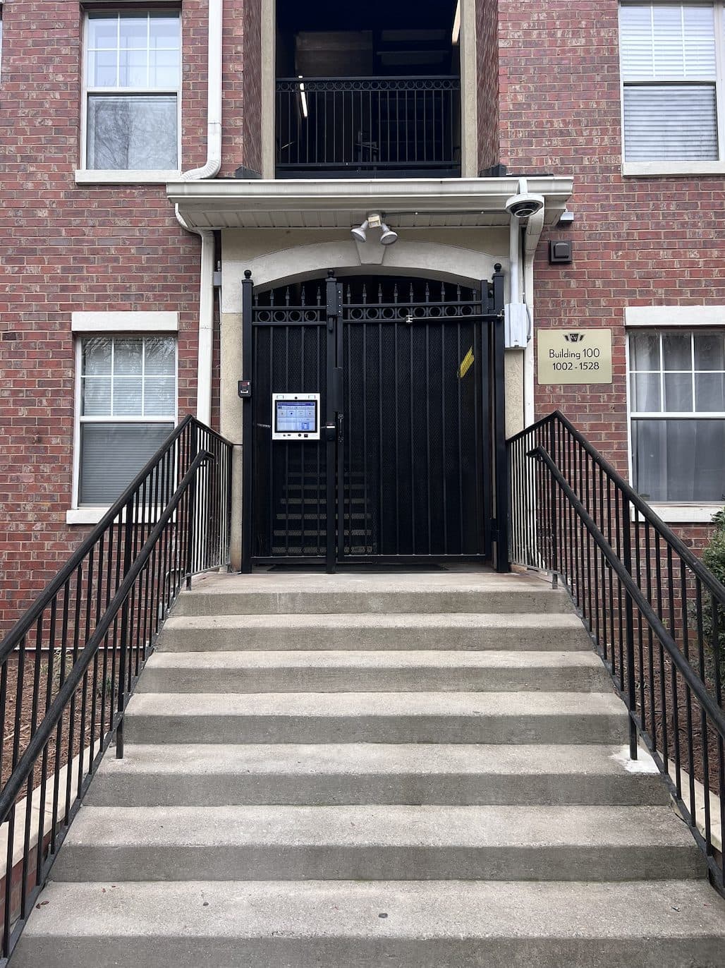 Black ornamental gate at apartment entrance with staircase in Georgia