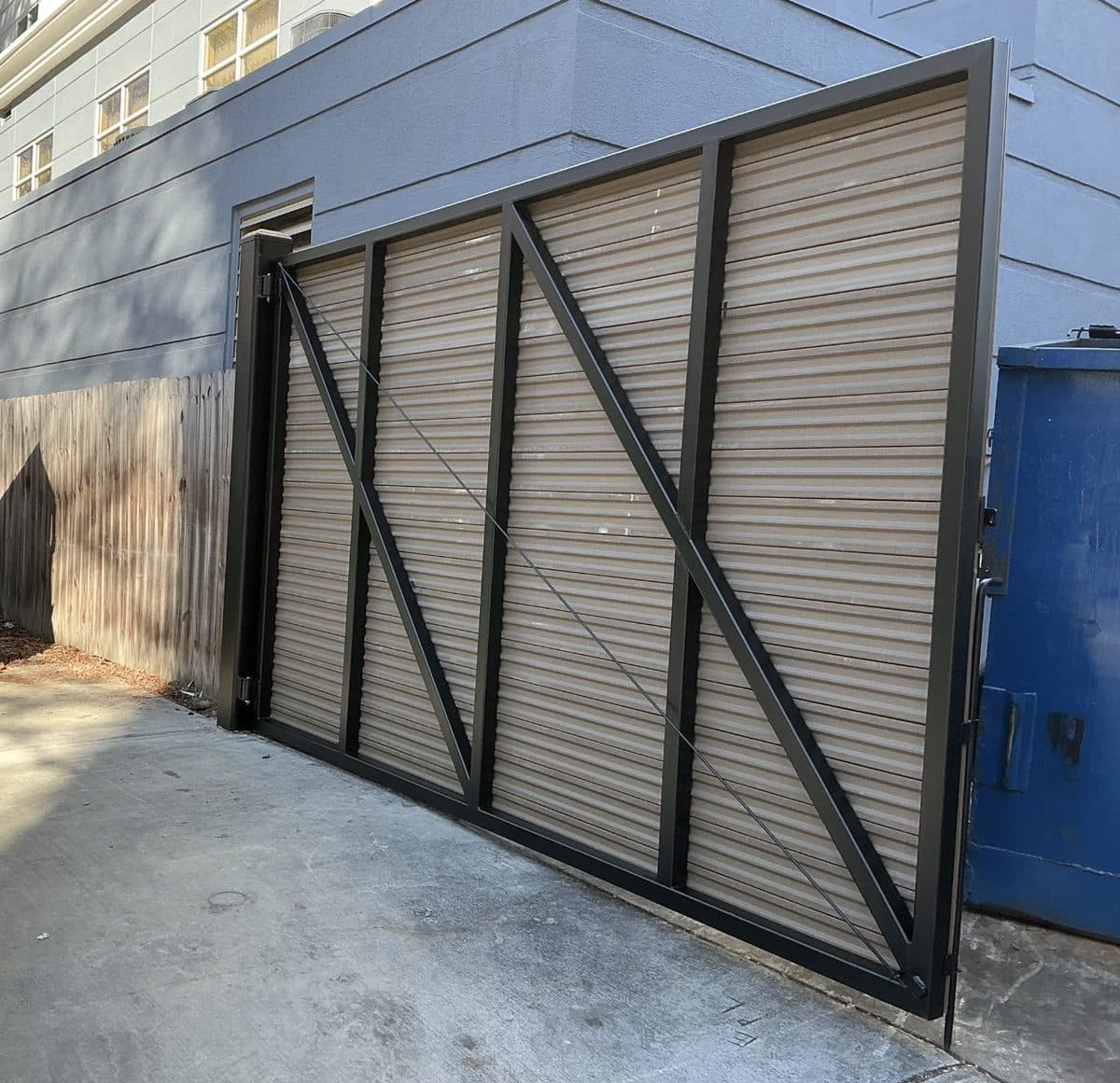Wide steel dumpster gate shown open at commercial property in Georgia