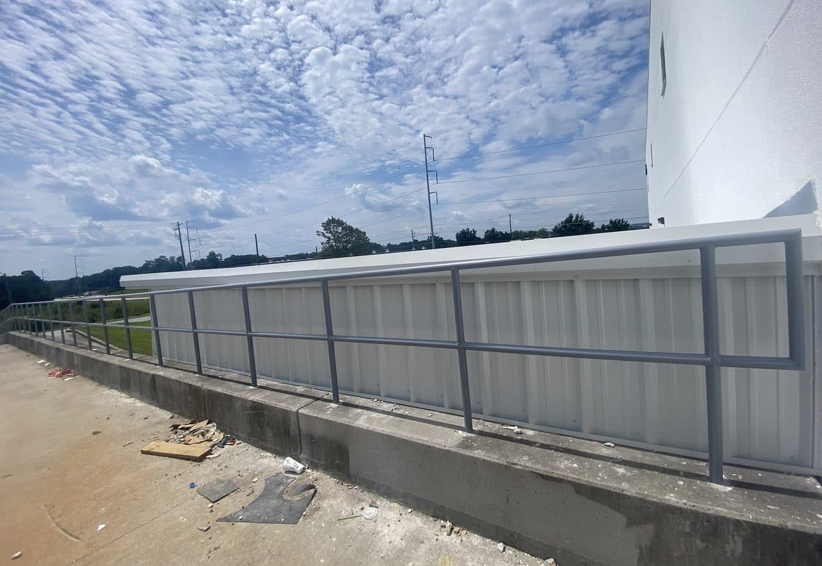 Steel safety railing with panel infill along concrete wall in Georgia