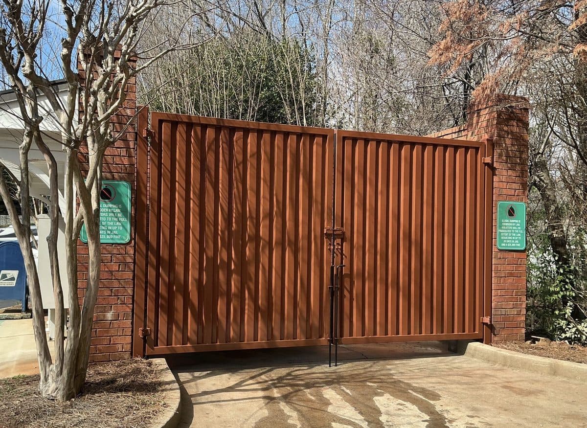 Wood finish dumpster gate installation in brick columns, Atlanta, GA
